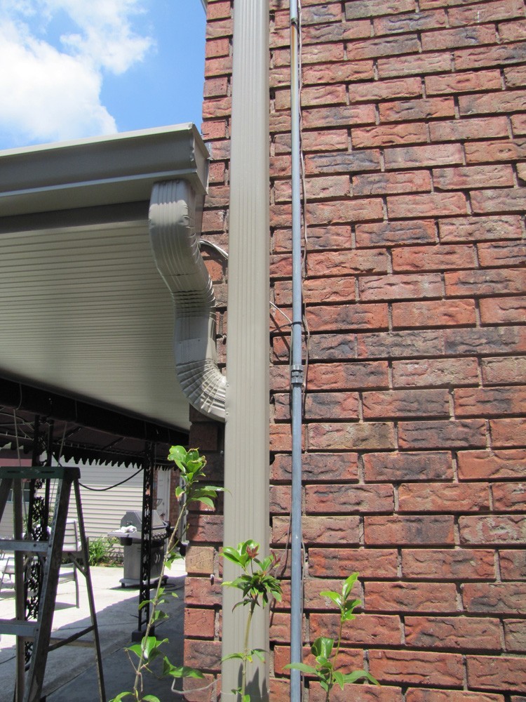 Tan gutters on brick in New Orleans - Strong Shield