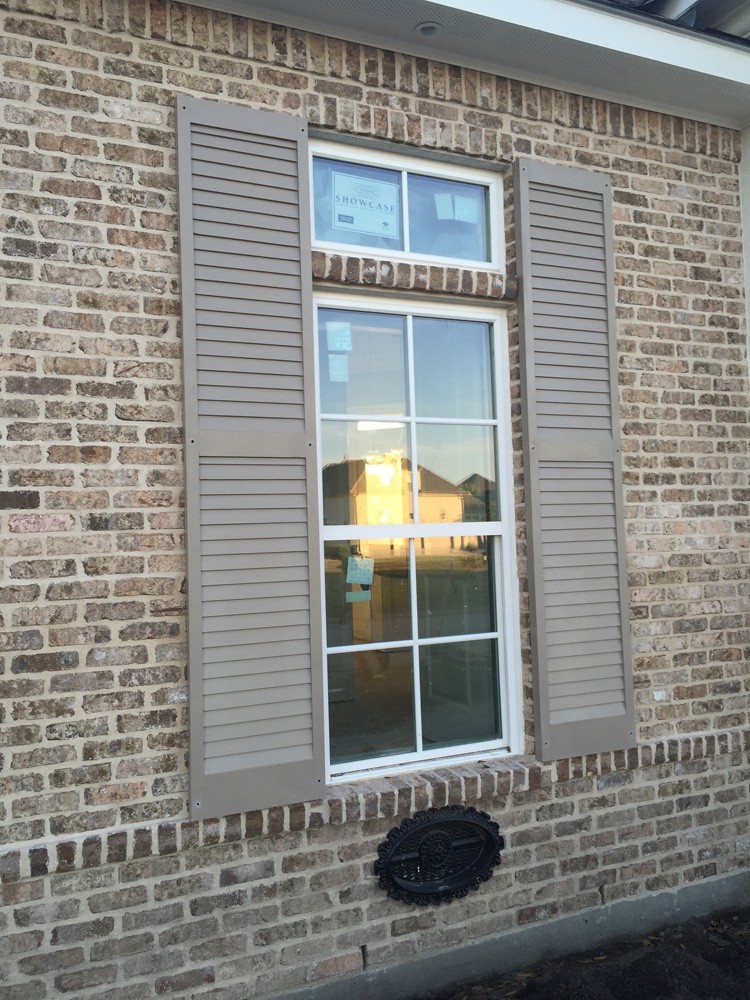 Tan shutters on New Orleans brown brick home - Strong Shield