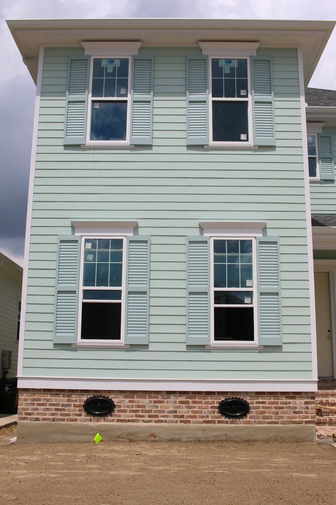 Shutters on green home with red brick in New Orleans - Strong Shield