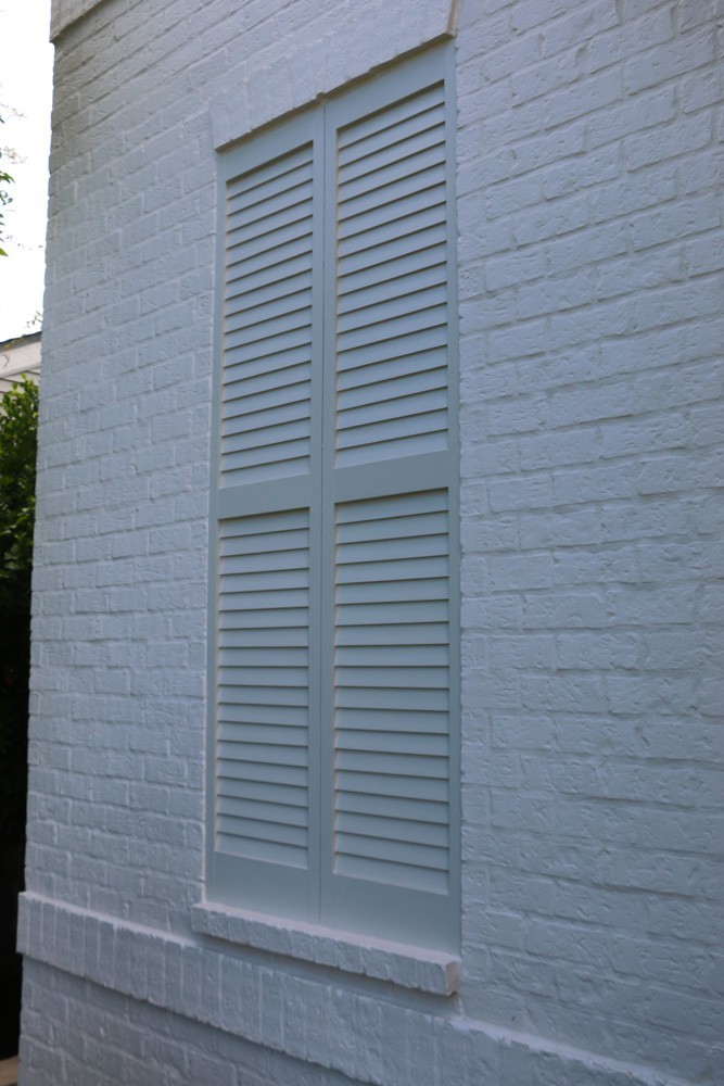 White shutters on white brick home - Strong Shield