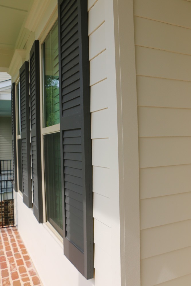 Shutters on white home with brick floor porch - Strong Shield
