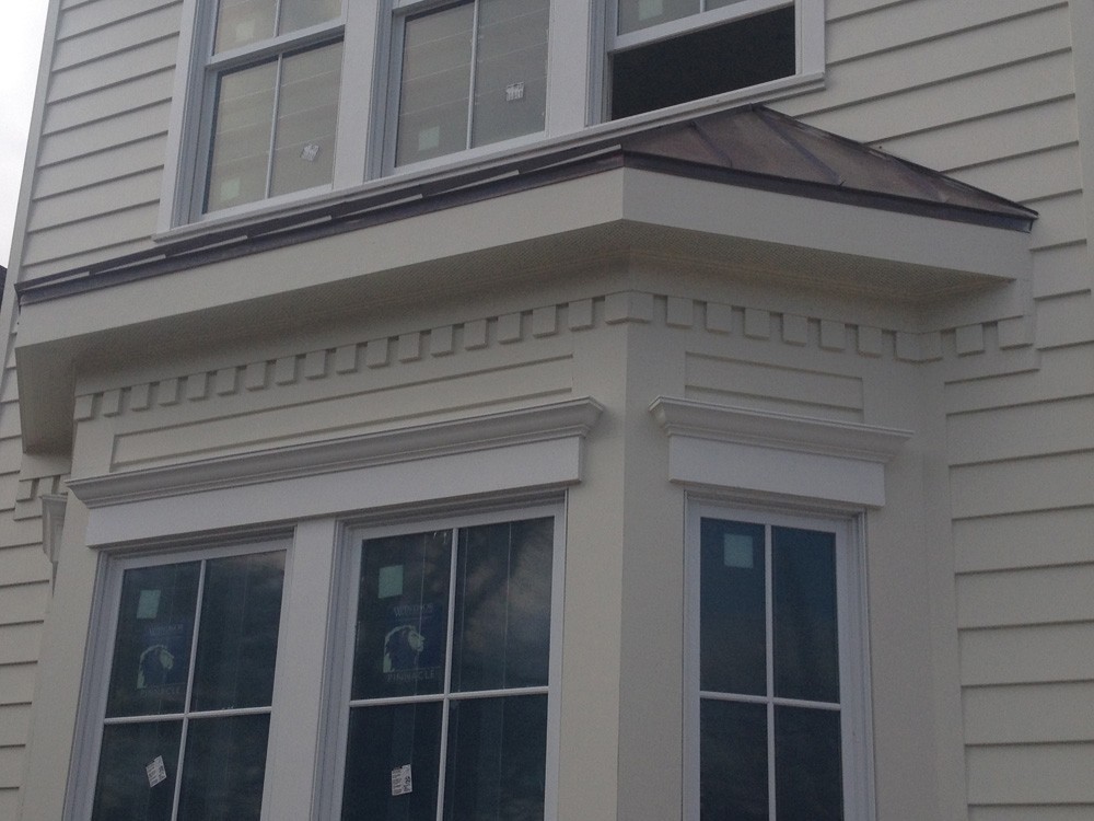 Dentil molding below eaves and molding above windows - Strong Shield