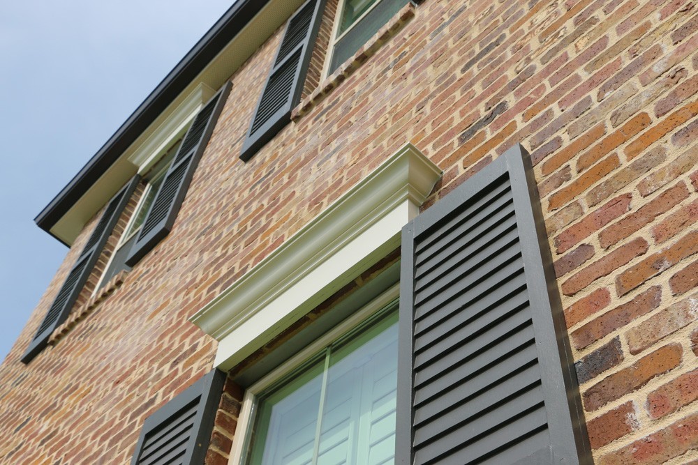 Louvered panel shutters with craftsman window top trim - Strong Shield