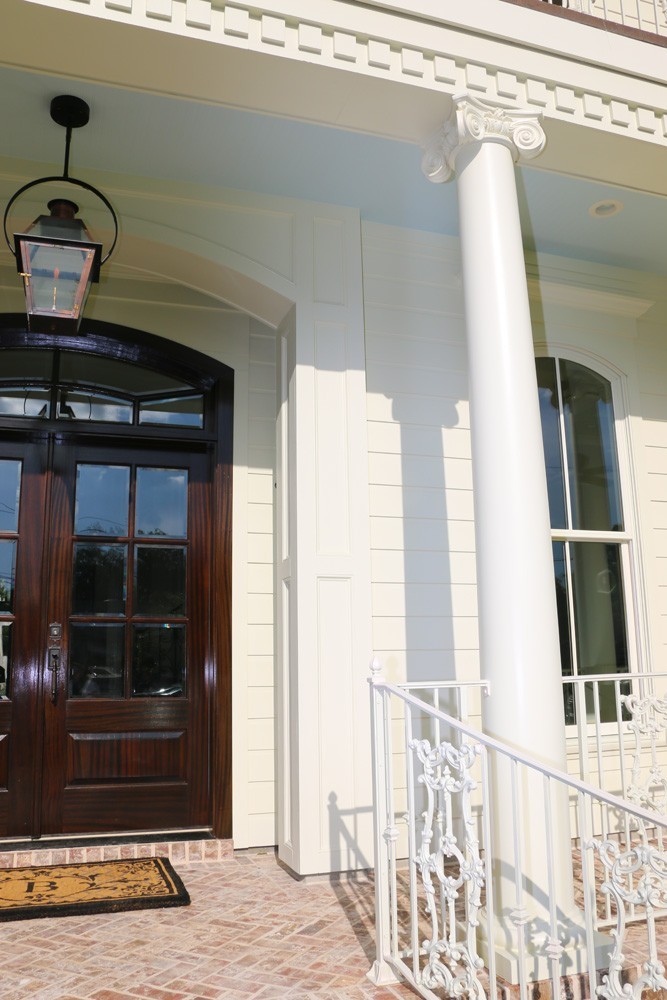 Round columns, dentil molding, and iron railing on New Orleans home - Strong Shield