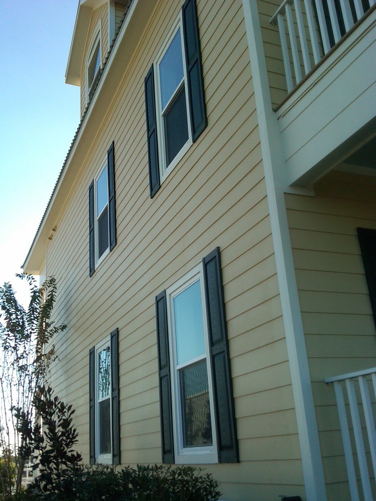 Home painted yellow with black shutters - Strong Shield