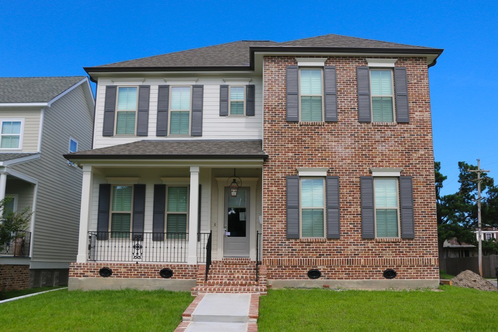 Shutters on red brick and white siding home - Strong Shield