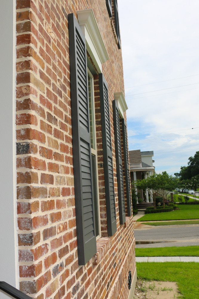 Red brick home with wood shutters - Strong Shield