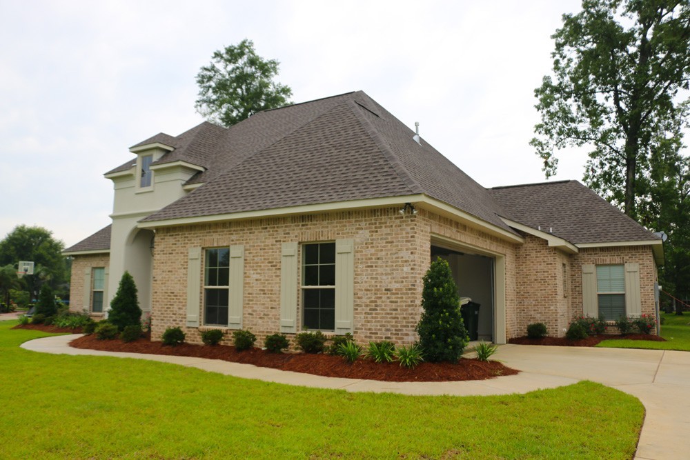 Light sage shutters on brick and stucco home - Strong Shield