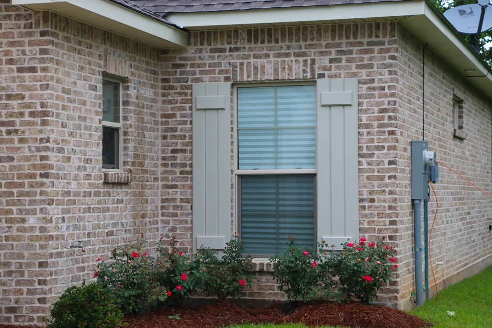 Board and batten shutter style on brick home - Strong SHield